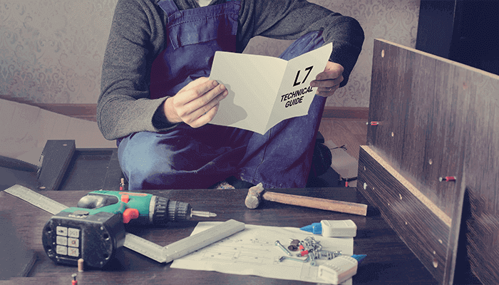 Frustrated man reading instruction and putting together self assembly furniture